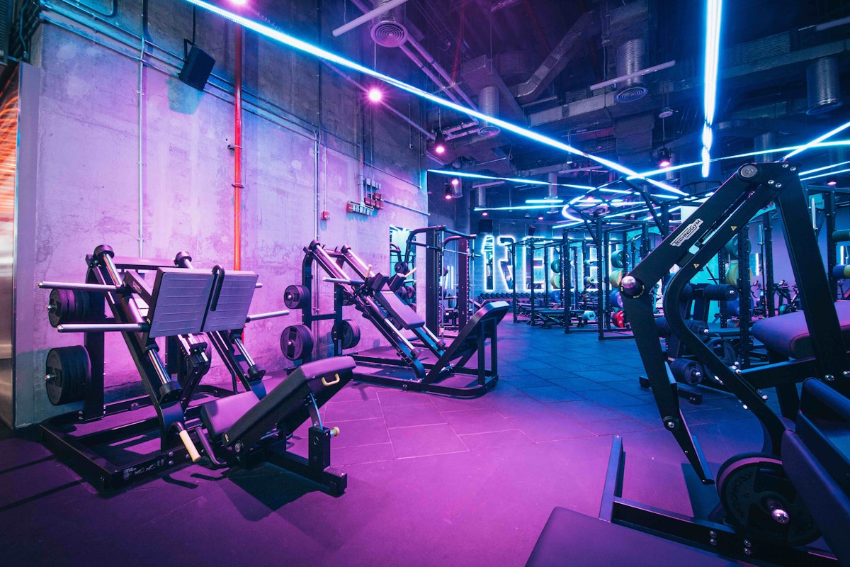 1Rebel Modern fitness machines in neon-lit, industrial-style gym.