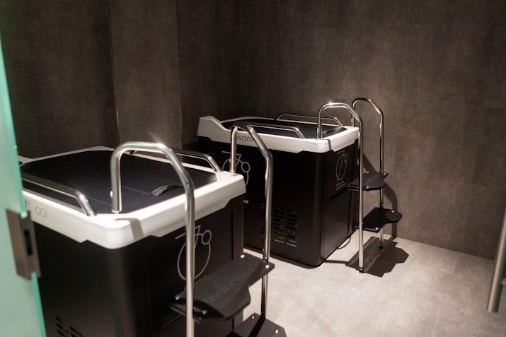 Two plunge pools with steps inside a small treatment room.
