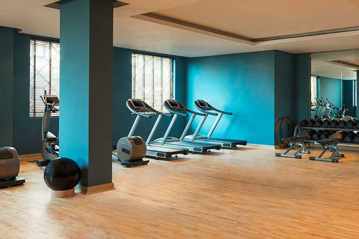 Gym with treadmills, weights, and blue walls