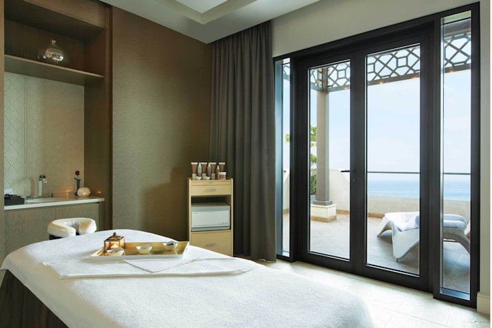 Luxury spa room with massage table and balcony view