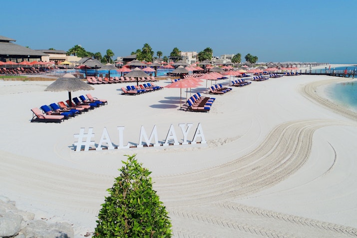 Beach with lounge chairs and umbrellas on white sand