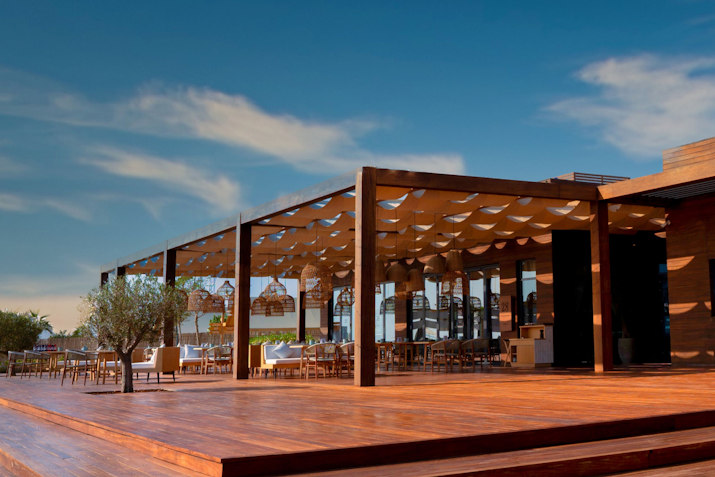 Bab Al Nojoum Outdoor restaurant with wooden deck and decorative overhead canopy.