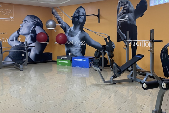 Gym with exercise equipment and wall art.