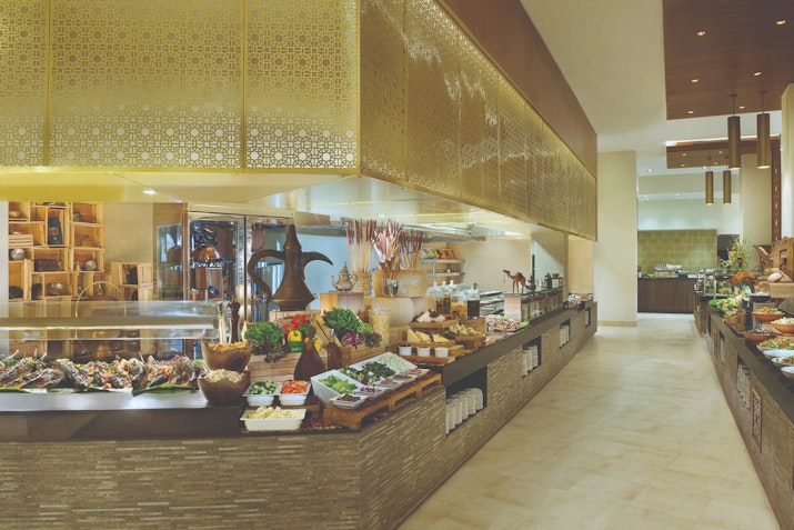 Interior view of a buffet restaurant with a variety of food displayed on the counter.