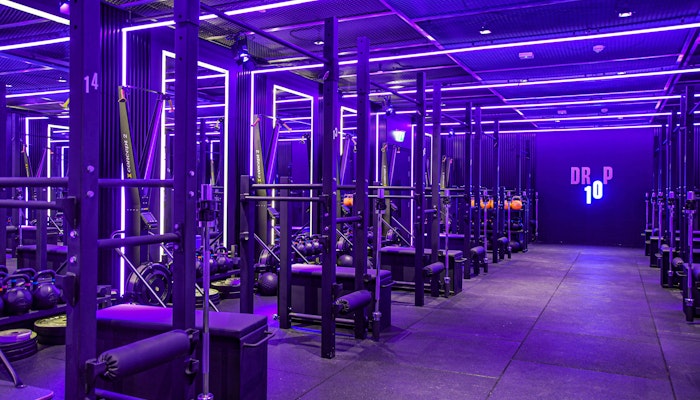 Drop10 Dark fitness studio with neon lights and a variety of fitness equipment