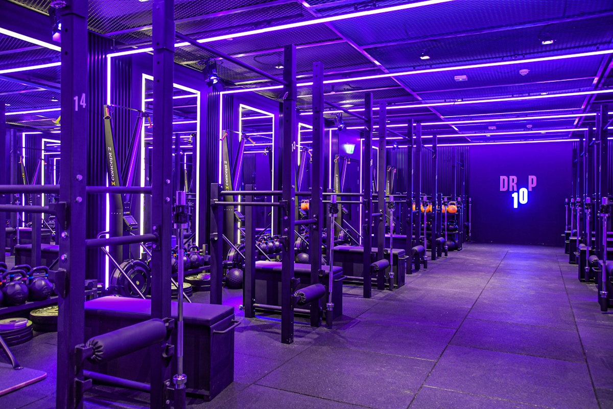 Drop10 Dark fitness studio with neon lights and a variety of fitness equipment