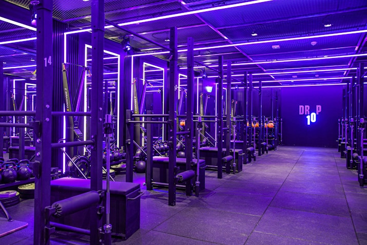 Dark fitness studio with neon lights and a variety of fitness equipment