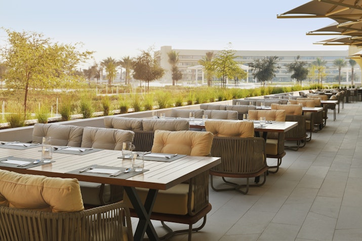 Outdoor dining area with cushioned seating and tables.