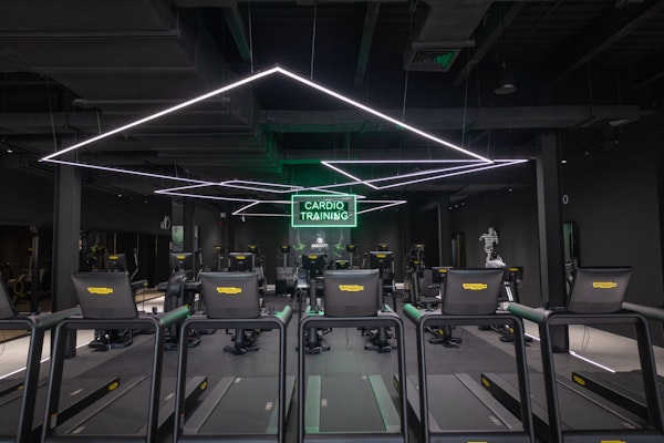 Transform Your Career with Privilee's Corporate Wellness Programme: modern gym with cardio equipment and sleek design.