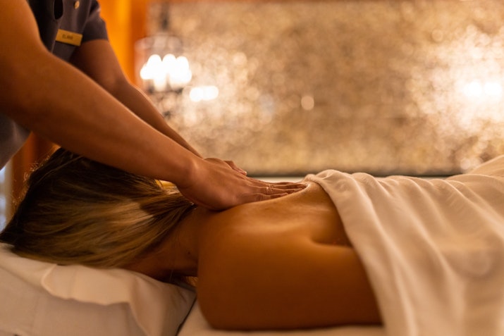 InterContinental Ras Al Khaimah A therapist giving a massage to a woman lying on a treatment table, with soft lighting in the background.