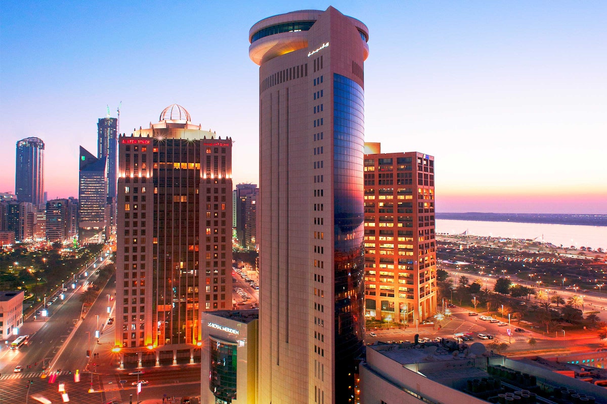 Cityscape with illuminated skyscrapers at sunset.