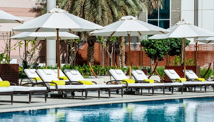 Le Royal Meridien Abu Dhabi Poolside lounge chairs with white umbrellas.