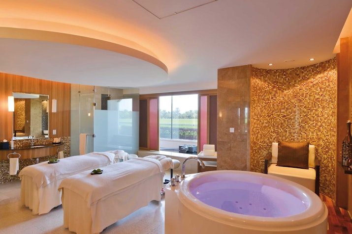 Melia Desert Samana Spa Luxurious spa room with massage tables and a jacuzzi