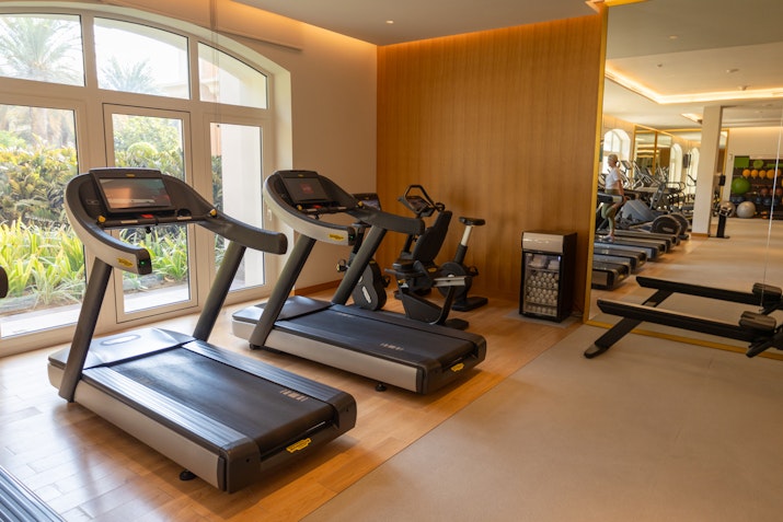 A modern gym interior featuring several treadmill machines and exercise equipment.