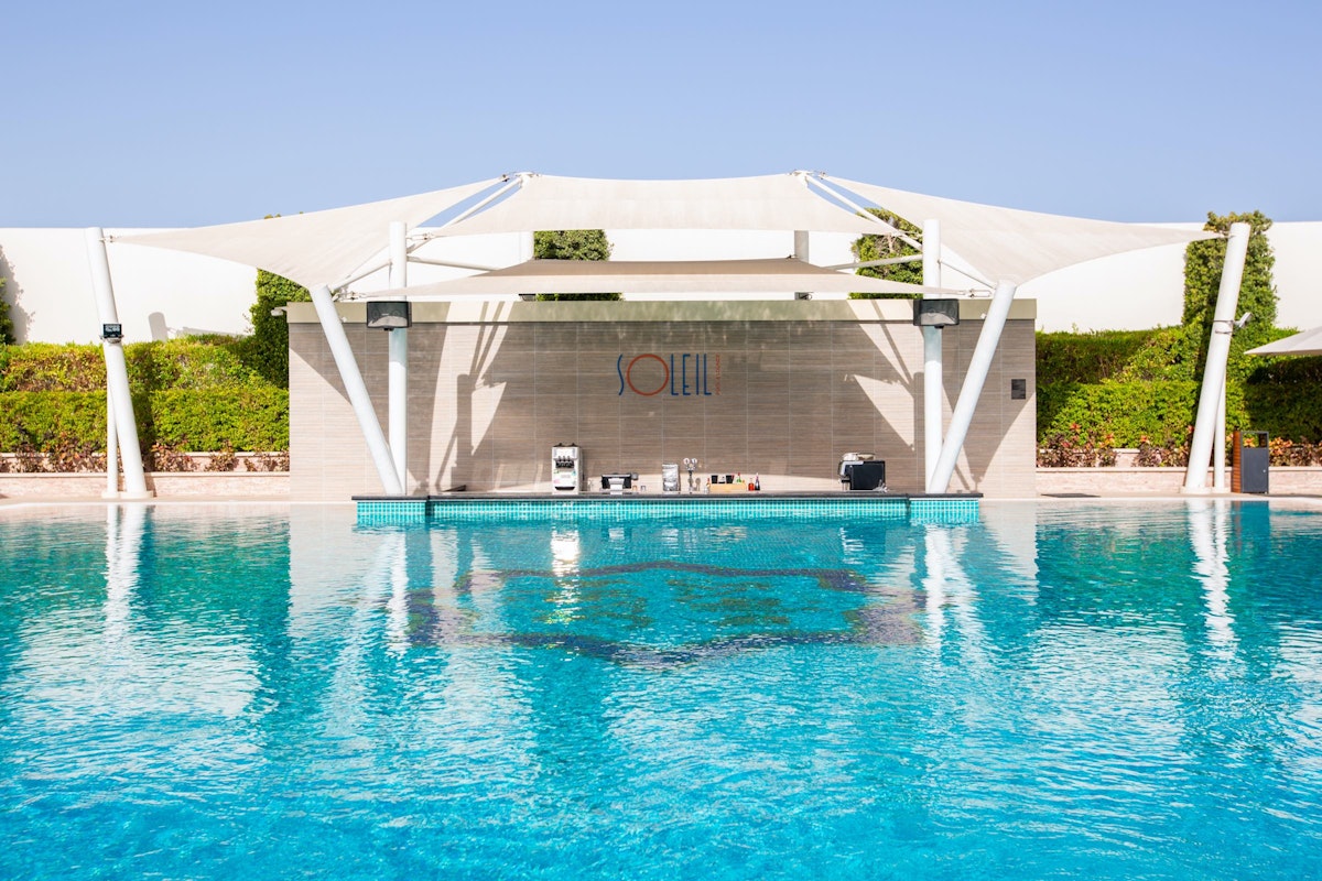 Soleil Pool & Lounge, Sofitel Dubai The Obelisk Pool with a bar area under a large white canopy.