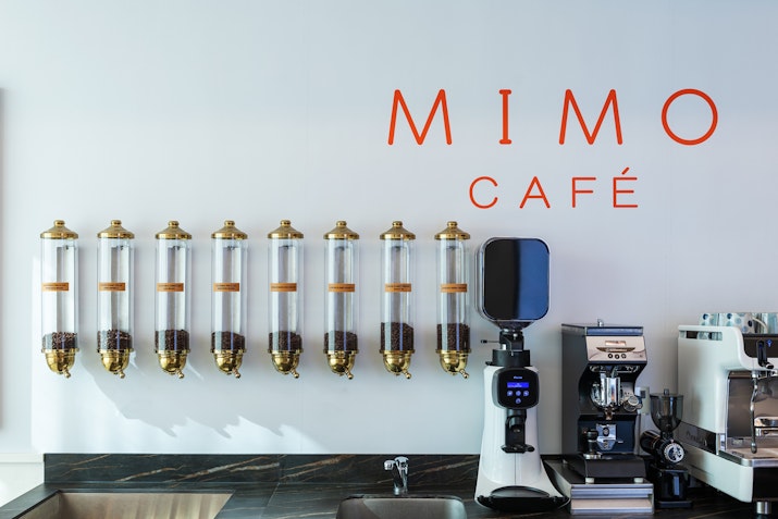 Mimo Café at TH8 Palm Dubai Beach Resort Mimo Café counter with coffee dispensers and espresso machines.
