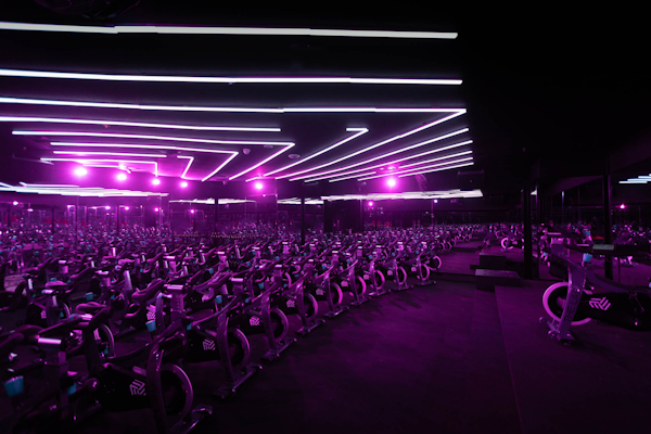 Indoor cycling class at SYCLE in The LAB Studio, featuring stationary bikes and dynamic lighting for an immersive experience.