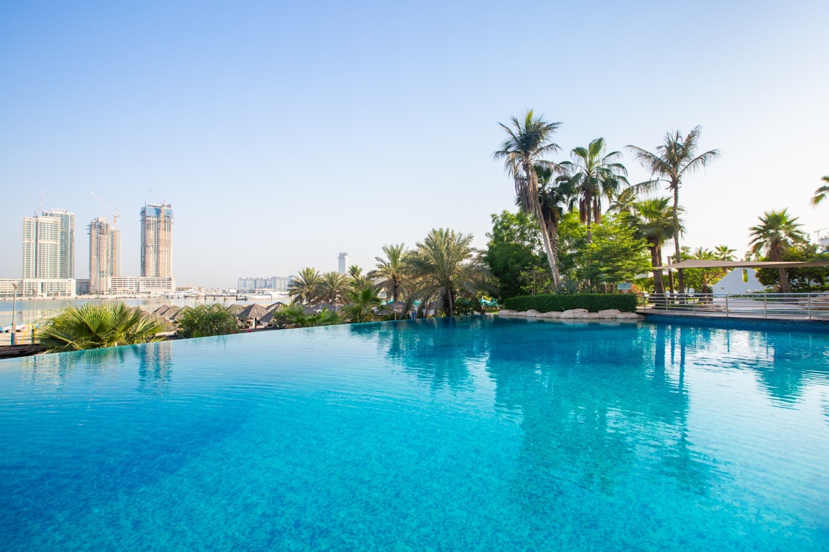 The Westin Dubai Mina Seyahi Beach Resort & Marina Infinity pool with city skyline and palm trees in the background.