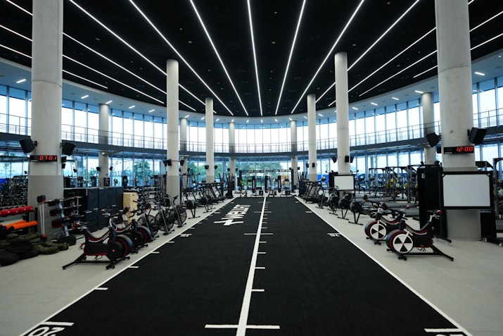 Bright and spacious fitness area at Wellfit Madar with expansive windows and modern workout equipment.