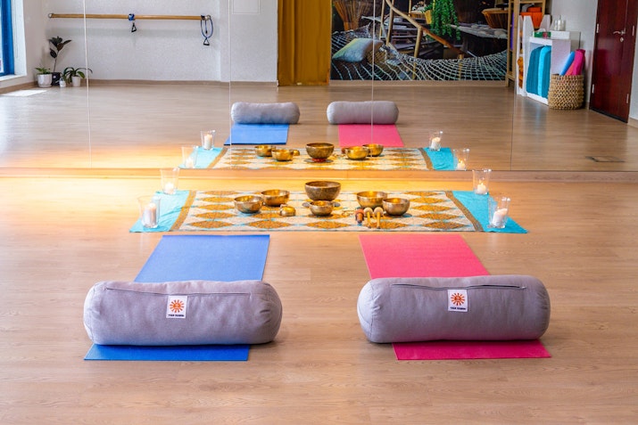 Yoga studio with wooden floors, mirrors, and props