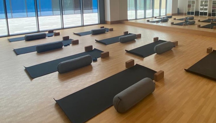 Zen Yoga Jumeirah Park Pavilion Peaceful yoga studio at Jumeirah Park Pavilion with natural lighting, floor-to-ceiling windows, yoga mats, and props