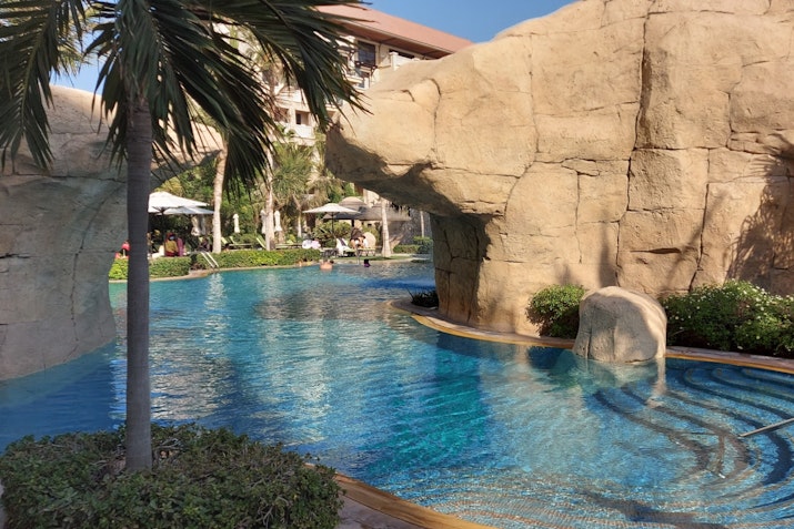 A picturesque pool surrounded by rock formations and tropical greenery.