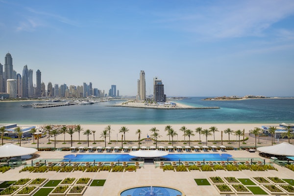 Resort pool area overlooking the beach and city skyline.
