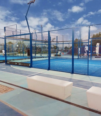 Play Padel Paddle courts with blue flooring and protective fencing.