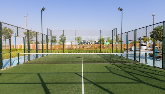 321 Sports Outdoor tennis or padel court with surrounding fencing and clear blue sky