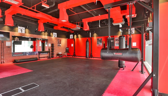 Final Round Boxing A boxing gym with red decor, punching bags, and workout equipment.