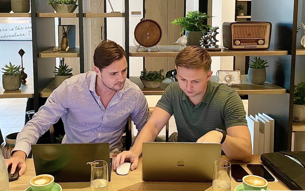 Privilee, for your business! Two professionals collaborating on laptops in a stylish office setting.