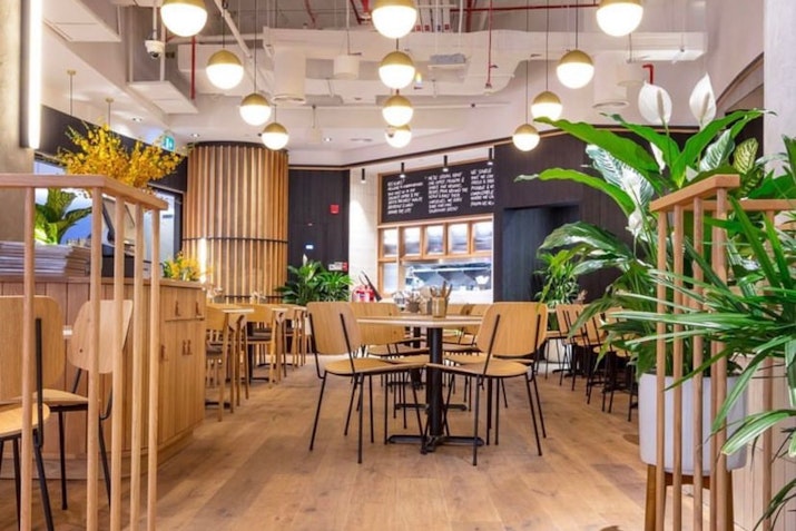 Modern cafe interior with wooden decor and hanging lights.