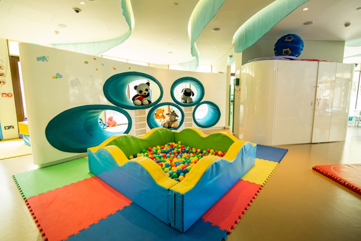 Indoor play area with a ball pit and colorful soft flooring