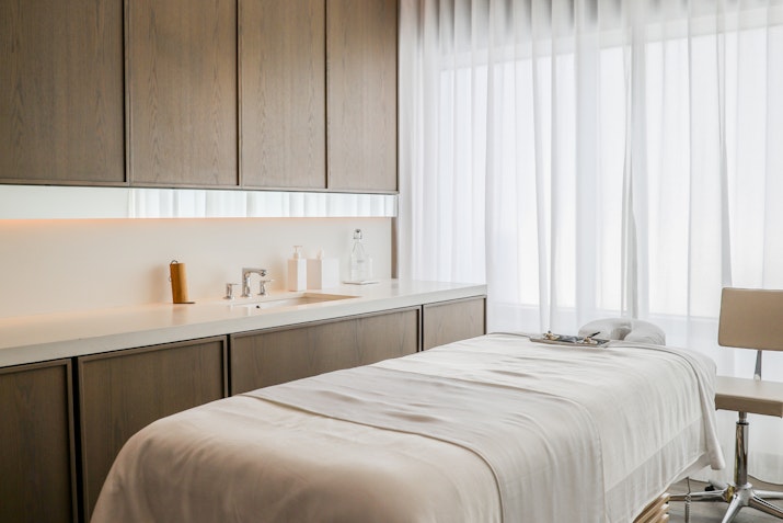 A clean and serene spa treatment room with a massage table.