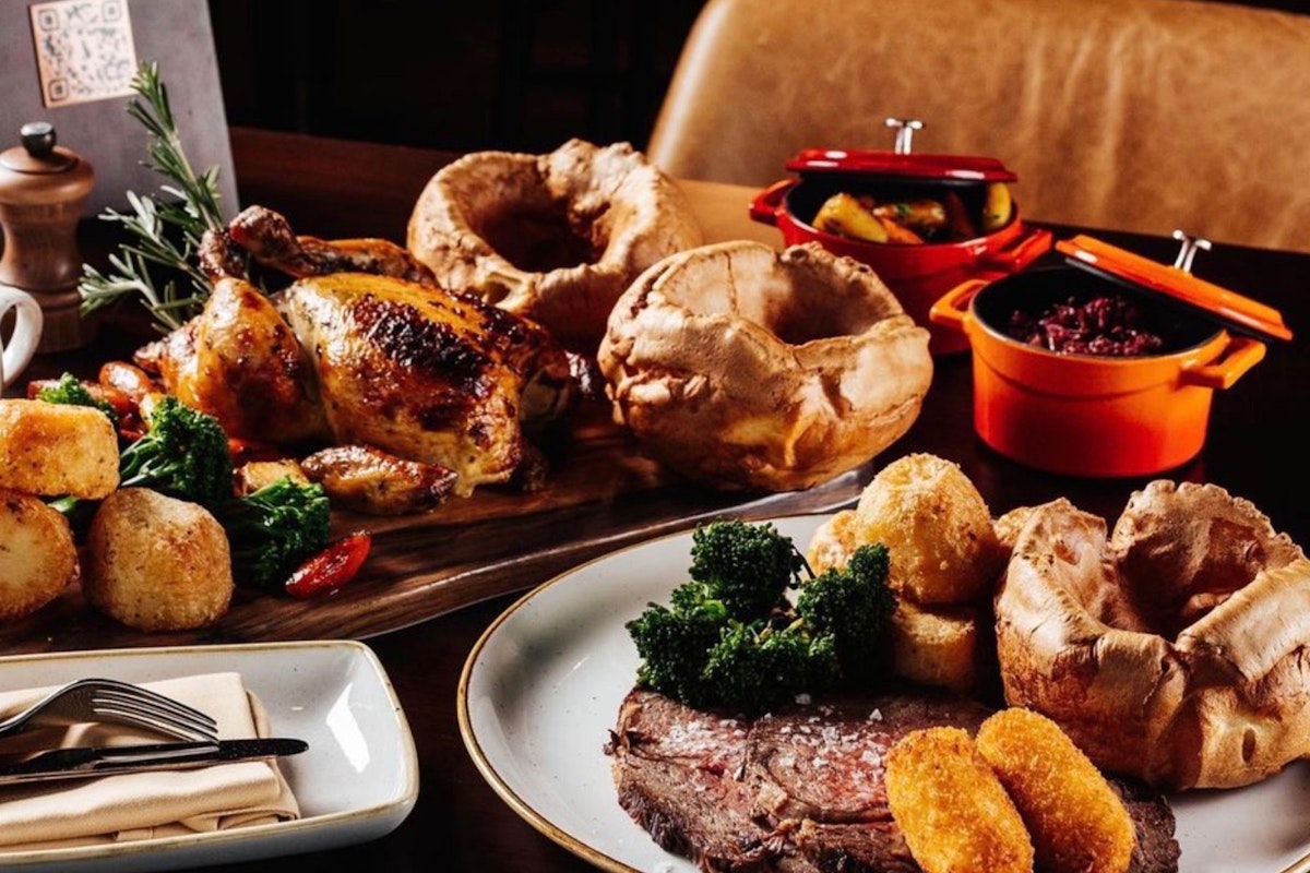 Featuring roast chicken, beef, Yorkshire puddings, and a variety of sides, perfect for a satisfying meal.