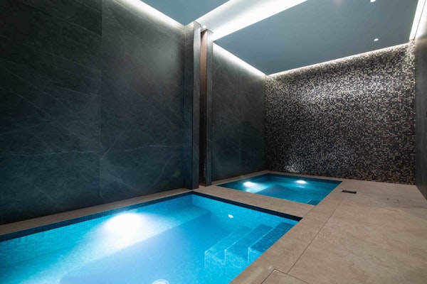 Small plunge pools in a dimly lit room with grey tiles walls