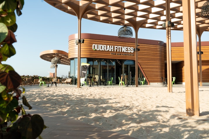 Outdoor fitness center with modern architecture and sand-covered surroundings