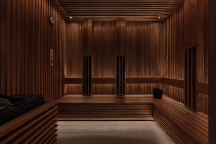 Saunas Elegant sauna interior with wooden paneling, soft lighting, and a relaxing atmosphere for a soothing experience.