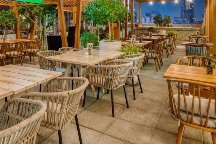 Savour Southern French Cuisine at Village Bistro: a relaxed, inviting dining space. Cozy outdoor seating with rustic decor and greenery.