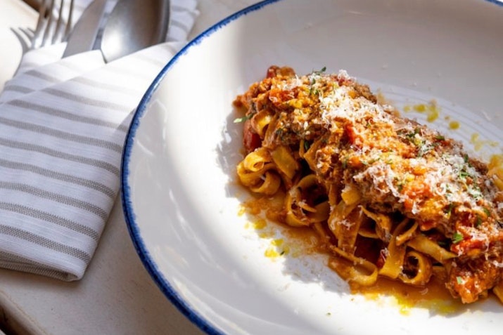 Indulge in authentic flavors with every bite. Plate of pasta with rich sauce and cheese.