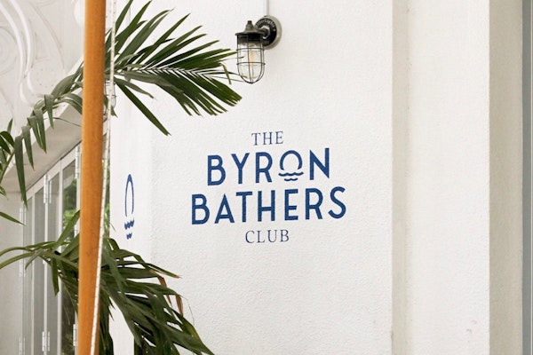 Savour The Shoreline’s Finest at The Byron Bathers Club: stylish exterior with tropical plants.