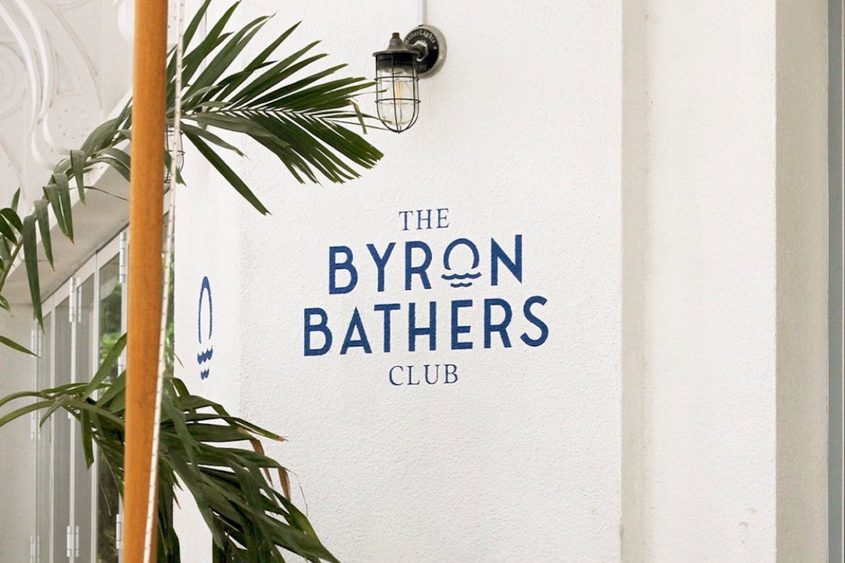 Savour The Shoreline’s Finest at The Byron Bathers Club: stylish exterior with tropical plants.