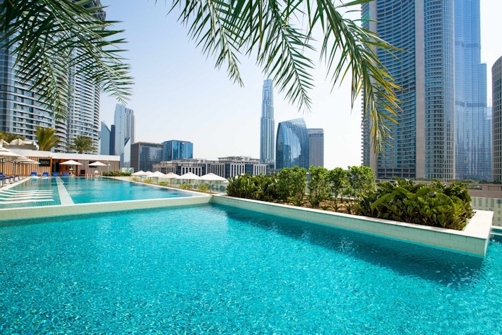 Rooftop pool with a view of city skyscrapers.