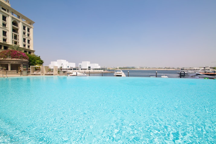 Infinity pool overlooking the water with a view of buildings.