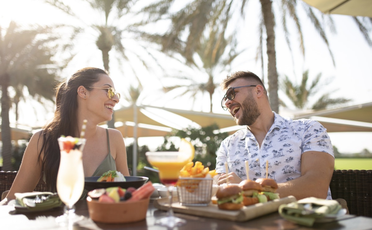 Couple eating under shaded palms