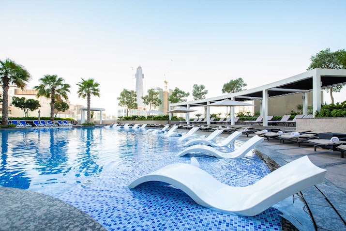 Poolside lounge chairs partially submerged in water