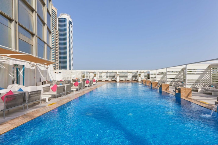 Media One Hotel Rooftop pool area with seating and city view.