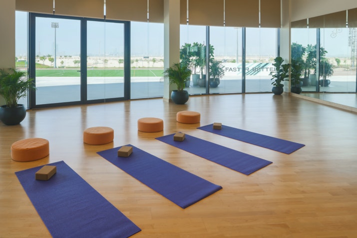 Yoga mats and cushions arranged in a bright studio.