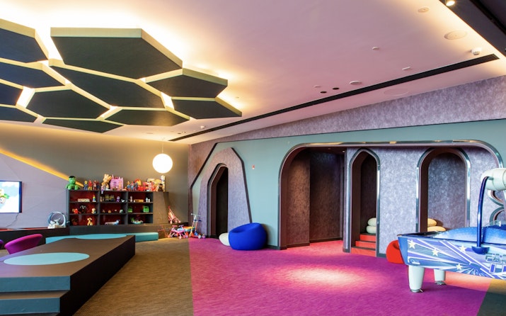 Children's playroom featuring colorful furniture, toys, and themed play areas, with a vibrant, modern design.