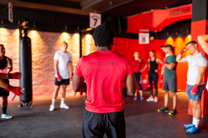Fitness instructor leading a group workout session in a gym